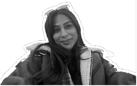 Black-and-white portrait of Mahita, smiling, with sunglasses pushed up on the head and a shearling-collared jacket